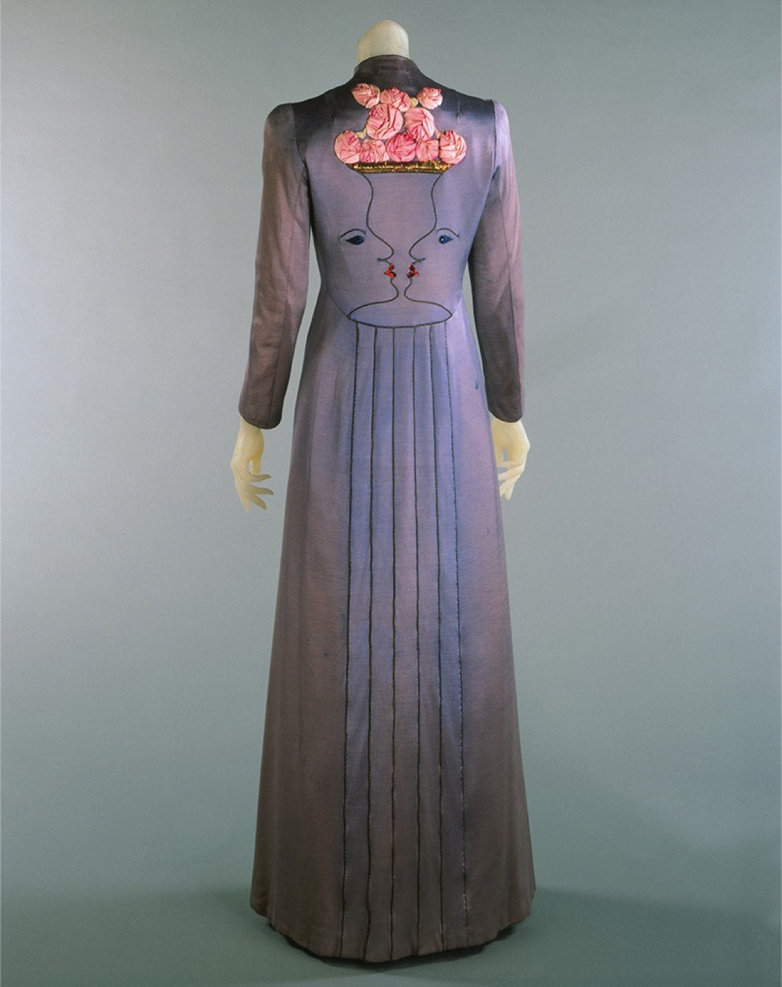 MANTEAU SCHIAPARELLI BRODÉ DE DEUX VISAGES EN TROMPE L’ŒIL ET ROSES SHOCKING